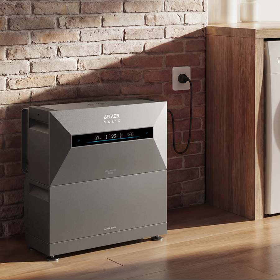 Anker air purifier next to a washing machine in a laundry room with brick wall.